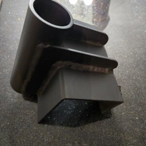 Metal part with welded joints on surface.