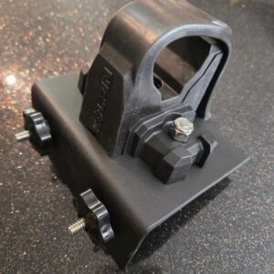 Black plastic mounting bracket on speckled surface.