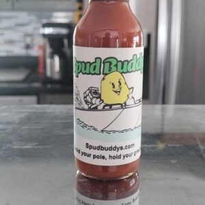 Hot sauce bottle on reflective surface.